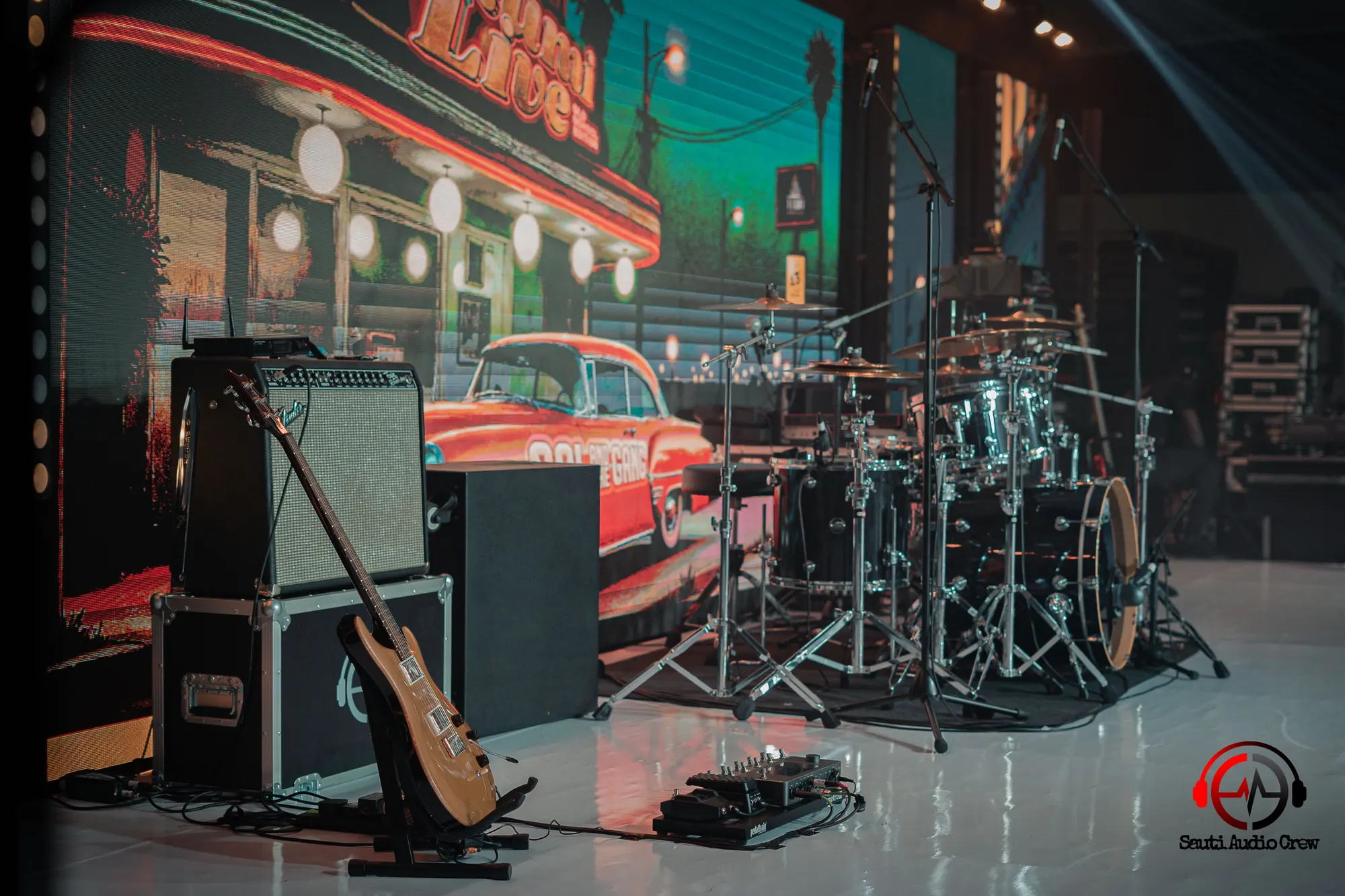 Drum kit, guitar amplifier and flight cases set up on stage
