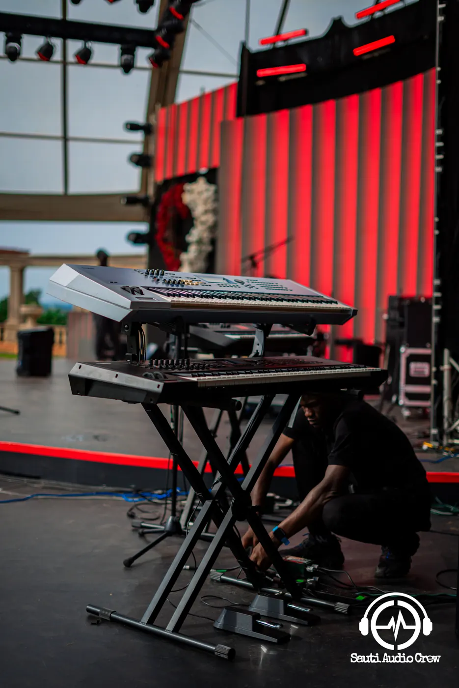 Sauti technician setting up a keyboard rig on stage before the show