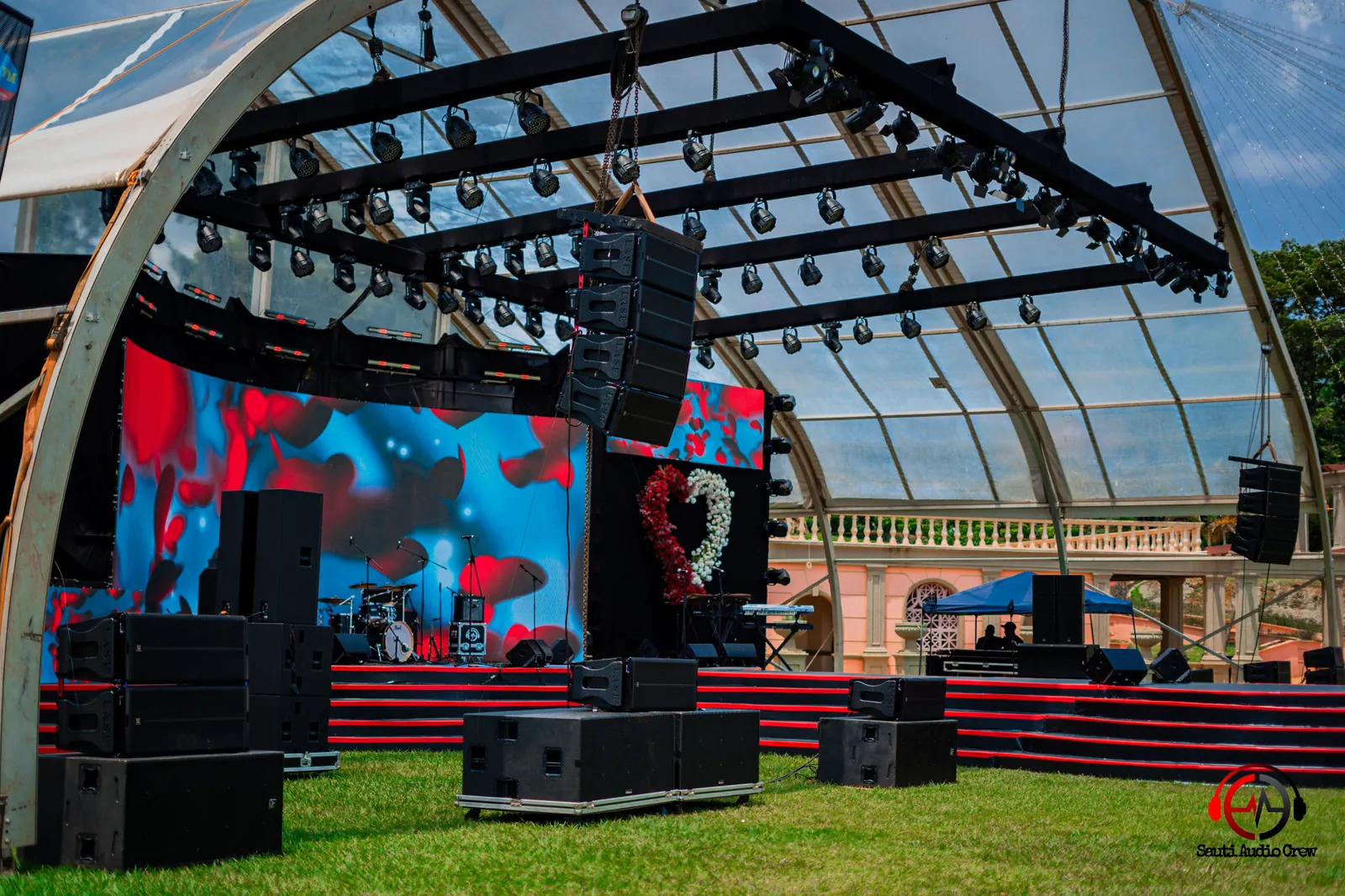 Outdoor tent stage with flown line-array speakers and subwoofers