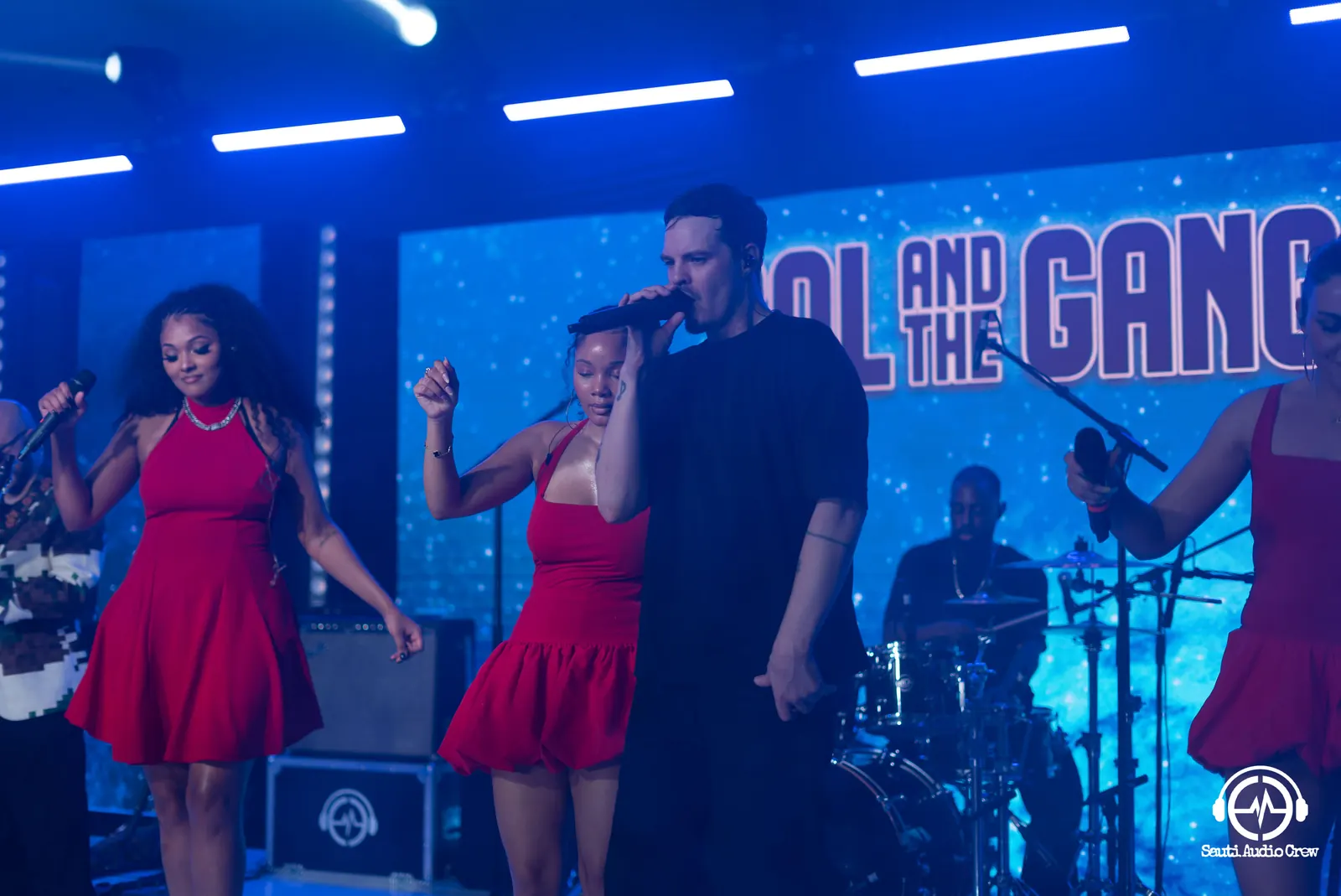 Sol and the Gang performing with vocalists in red